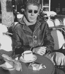 Bourdain in Europe with a baguette and a coffee